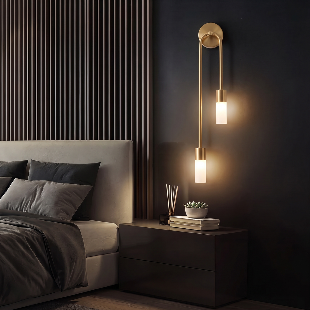 Gold twin-glow sconce beside a bed